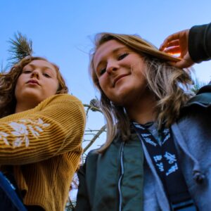 two women posing and looking down at the camera